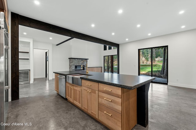 541 N Idaho Club Dr, Sandpoint, ID 83864 - kitchen featuring a sink, finished concrete floors, open floor plan, a stone fireplace, and dark countertops