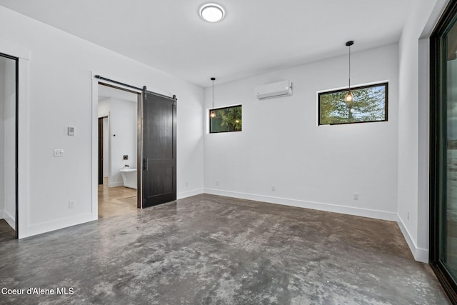 541 N Idaho Club Dr, Sandpoint, ID 83864 - unfurnished bedroom featuring a barn door, a wall mounted AC, multiple windows, and concrete floors