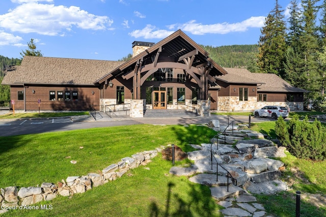 541 N Idaho Club Dr, Sandpoint, ID 83864 - back of property featuring french doors, a chimney, and a lawn
