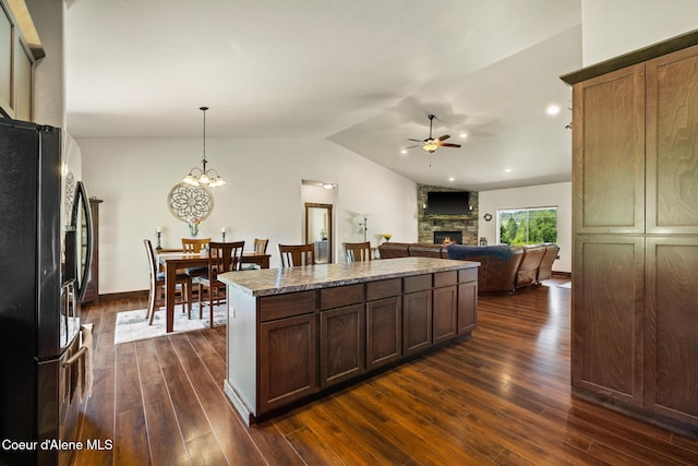 15268 S Potter Rd, Coeur Dalene, ID 83814 - kitchen with freestanding refrigerator, a fireplace, a ceiling fan, dark wood finished floors, and a kitchen island