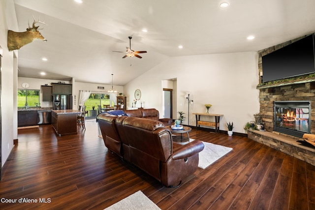 15268 S Potter Rd, Coeur Dalene, ID 83814 - living room featuring vaulted ceiling, a ceiling fan, a stone fireplace, dark wood-type flooring, and recessed lighting