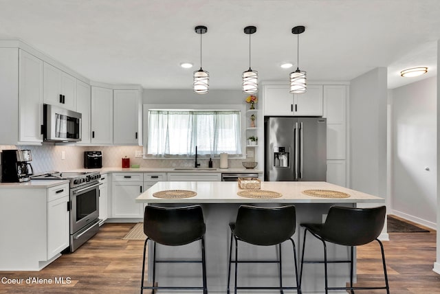 2040 Washington Ave, Saint Maries, ID 83861 - kitchen featuring appliances with stainless steel finishes, a kitchen bar, light countertops, backsplash, and a center island