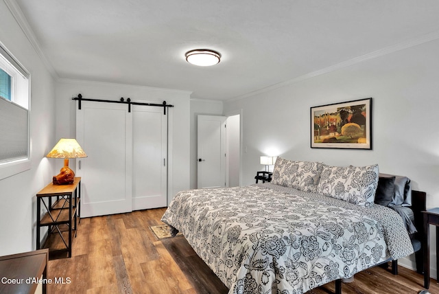 2040 Washington Ave, Saint Maries, ID 83861 - bedroom with a barn door, wood finished floors, ornamental molding, and a closet