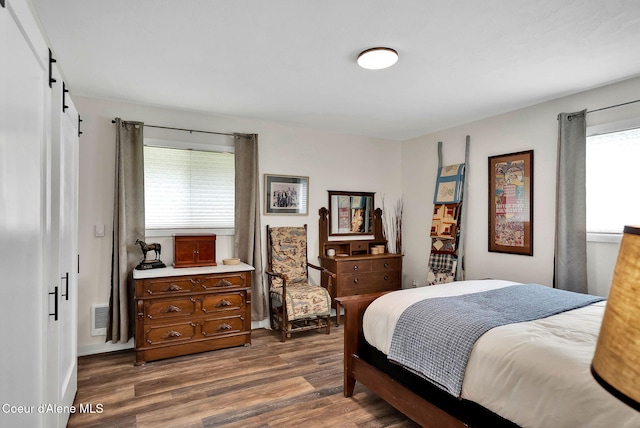 2040 Washington Ave, Saint Maries, ID 83861 - bedroom featuring multiple windows, dark wood-style flooring, and a barn door