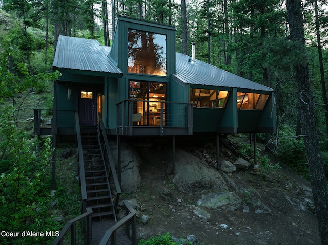 852 Woodland Dr, Sandpoint, ID 83864 - view of front of home featuring metal roof, stairs, and a wooded view