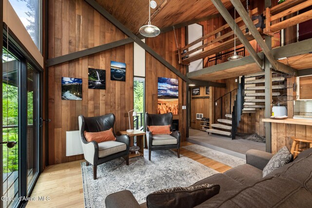 852 Woodland Dr, Sandpoint, ID 83864 - living room featuring a high ceiling, wooden walls, wood finished floors, and stairway