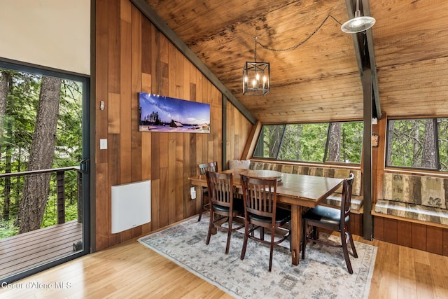 852 Woodland Dr, Sandpoint, ID 83864 - dining space with vaulted ceiling, wooden ceiling, wood walls, a chandelier, and light wood finished floors