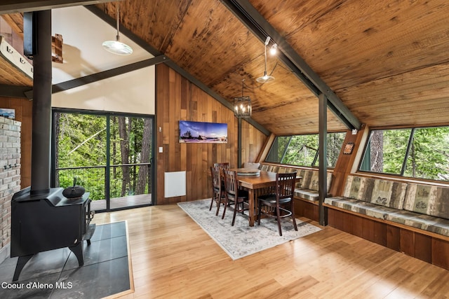 852 Woodland Dr, Sandpoint, ID 83864 - dining space with a wood stove, wood finished floors, wood ceiling, wood walls, and a chandelier