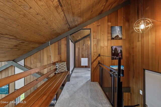 852 Woodland Dr, Sandpoint, ID 83864 - hallway featuring wood ceiling, an upstairs landing, vaulted ceiling, carpet floors, and wood walls
