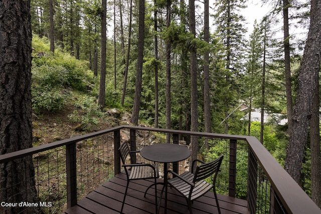 852 Woodland Dr, Sandpoint, ID 83864 - wooden terrace featuring outdoor dining space and a wooded view