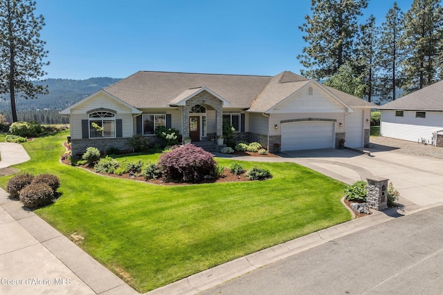 620 N Chisholm Ct, Post Falls, ID 83854 - view of front facade featuring stone siding, driveway, an attached garage, a front yard, and a mountain view