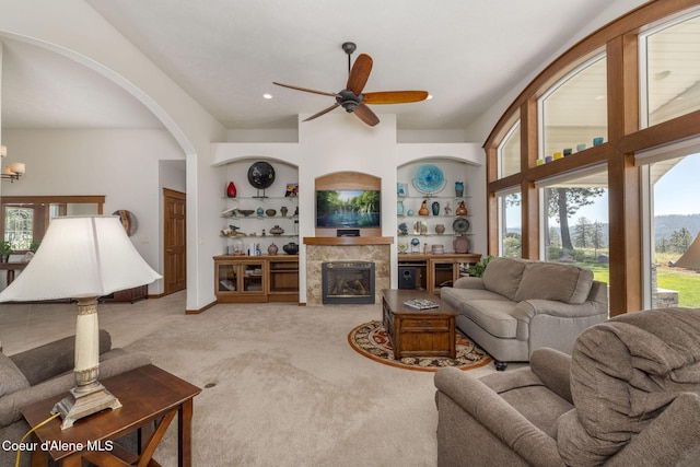 620 N Chisholm Ct, Post Falls, ID 83854 - living room with a ceiling fan, built in shelves, a tile fireplace, carpet flooring, and arched walkways