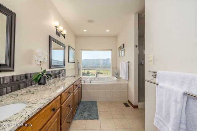 620 N Chisholm Ct, Post Falls, ID 83854 - bathroom featuring a garden tub, tile patterned floors, double vanity, a mountain view, and recessed lighting