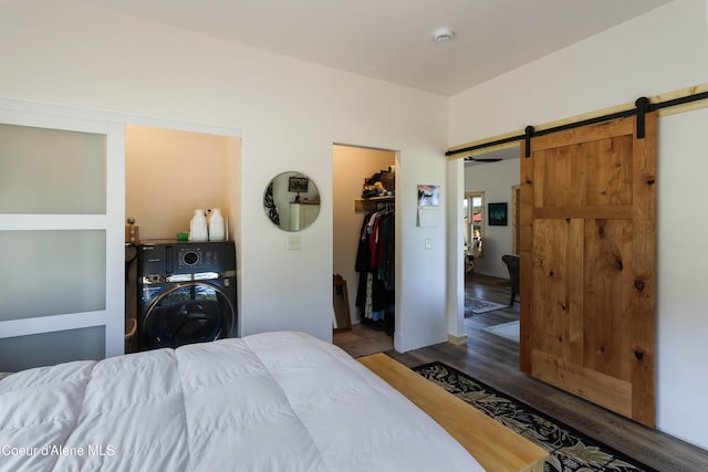 202 Elizabeth Ln, Athol, ID 83801 - bedroom with a barn door, wood finished floors, washer / clothes dryer, a walk in closet, and a closet