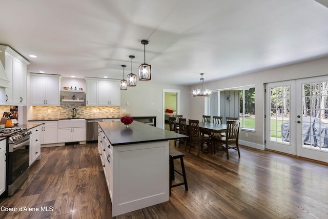245 Lost Creek Ln, Priest River, ID 83856 - kitchen featuring appliances with stainless steel finishes, dark countertops, open shelves, dark wood-type flooring, and decorative backsplash