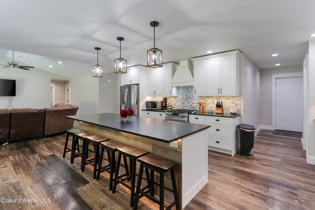245 Lost Creek Ln, Priest River, ID 83856 - kitchen featuring stainless steel appliances, dark countertops, custom exhaust hood, dark wood-style floors, and a ceiling fan