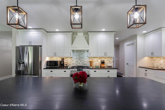 245 Lost Creek Ln, Priest River, ID 83856 - kitchen featuring stainless steel appliances, dark countertops, custom exhaust hood, recessed lighting, and tasteful backsplash