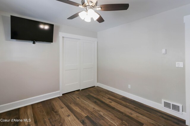245 Lost Creek Ln, Priest River, ID 83856 - unfurnished bedroom with baseboards, dark wood-style floors, a closet, and ceiling fan