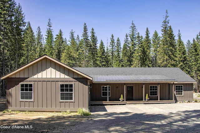 245 Lost Creek Ln, Priest River, ID 83856 - view of front of house with board and batten siding, covered porch, and a forest view