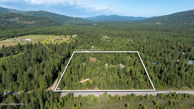13 Park Dr, Spirit Lake, ID 83869 - aerial view of property and surrounding area with a heavily wooded area, a mountainous background, and property parcel outlined