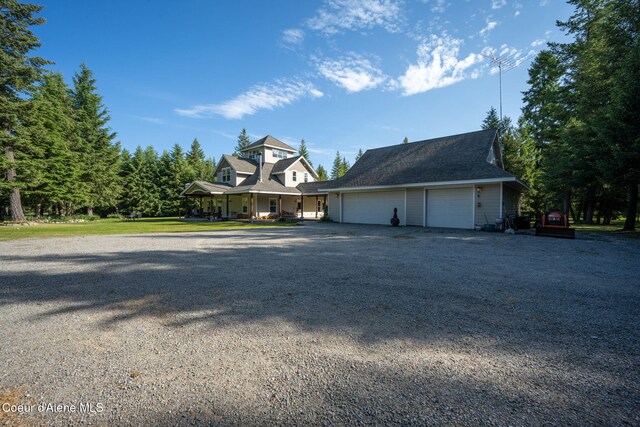 13 Park Dr, Spirit Lake, ID 83869 - view of side of home featuring covered porch, gravel driveway, and an attached garage