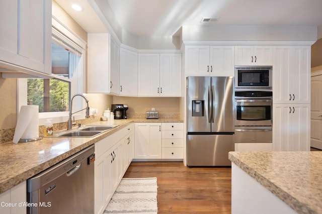 13 Park Dr, Spirit Lake, ID 83869 - kitchen with stainless steel appliances, a sink, white cabinetry, wood finished floors, and recessed lighting