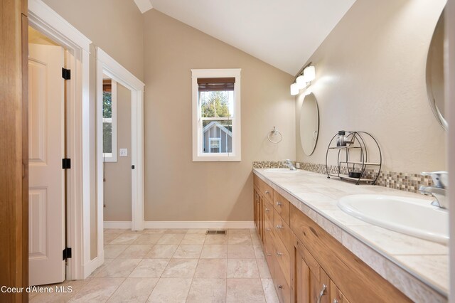 13 Park Dr, Spirit Lake, ID 83869 - bathroom featuring double vanity, lofted ceiling, and baseboards