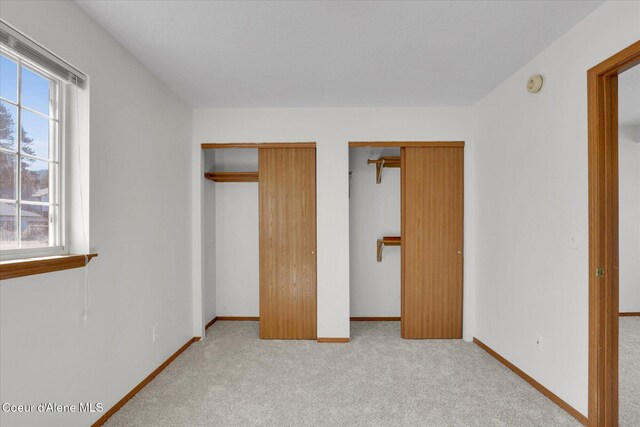 3203 N 12th St, Coeur Dalene, ID 83815 - unfurnished bedroom with carpet floors, multiple windows, and multiple closets