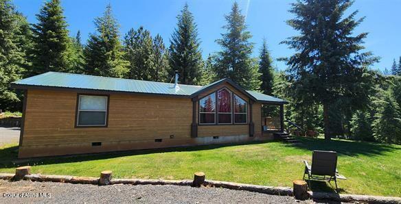229 Henderson Lp, Kamiah, ID 83536 - view of front facade featuring crawl space, a front yard, and a metal roof