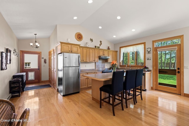 9307 Lakeshore Dr, Sagle, ID 83860 - kitchen with freestanding refrigerator, a chandelier, light wood-style flooring, a center island, and lofted ceiling