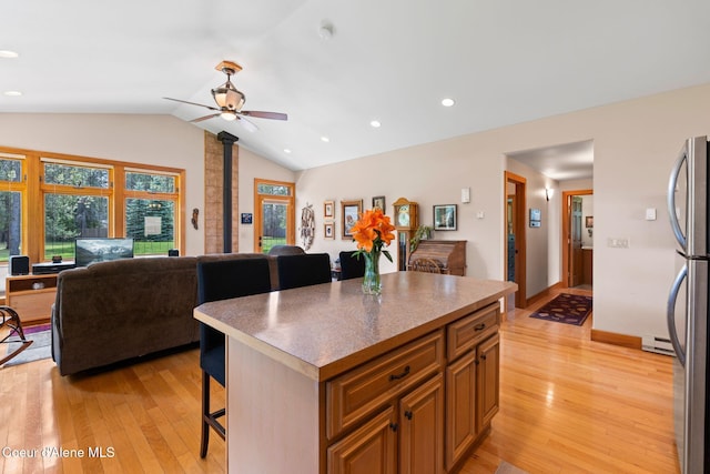 9307 Lakeshore Dr, Sagle, ID 83860 - kitchen with open floor plan, a breakfast bar area, light wood-type flooring, lofted ceiling, and ceiling fan