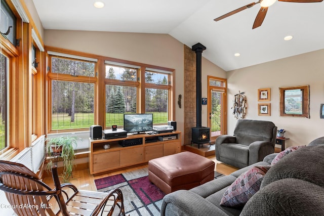 9307 Lakeshore Dr, Sagle, ID 83860 - living area with a wood stove, light wood finished floors, lofted ceiling, a ceiling fan, and plenty of natural light