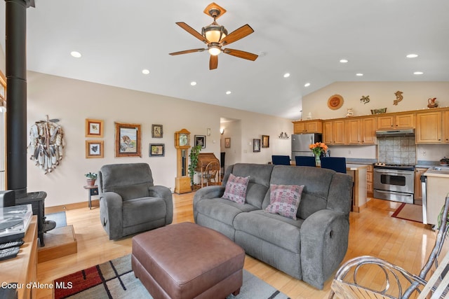9307 Lakeshore Dr, Sagle, ID 83860 - living room with a wood stove, a ceiling fan, light wood finished floors, vaulted ceiling, and recessed lighting