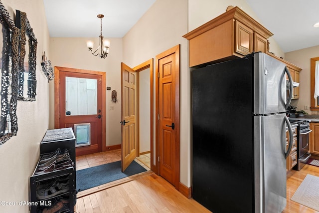 9307 Lakeshore Dr, Sagle, ID 83860 - kitchen featuring stainless steel appliances, light wood-style floors, a chandelier, and decorative light fixtures