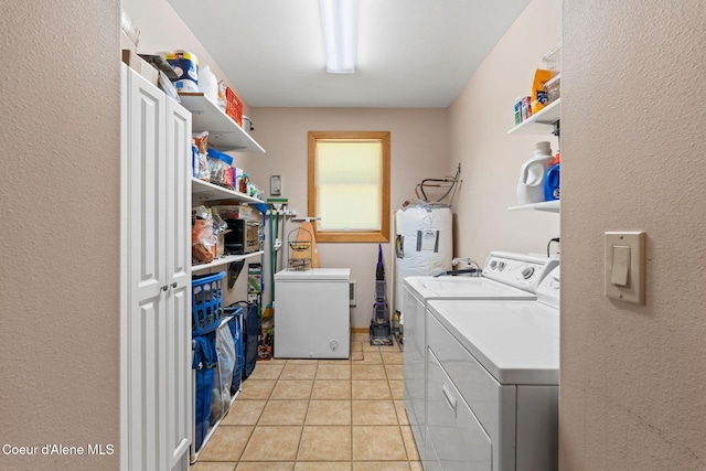 9307 Lakeshore Dr, Sagle, ID 83860 - laundry area with washer and clothes dryer, water heater, and light tile patterned flooring