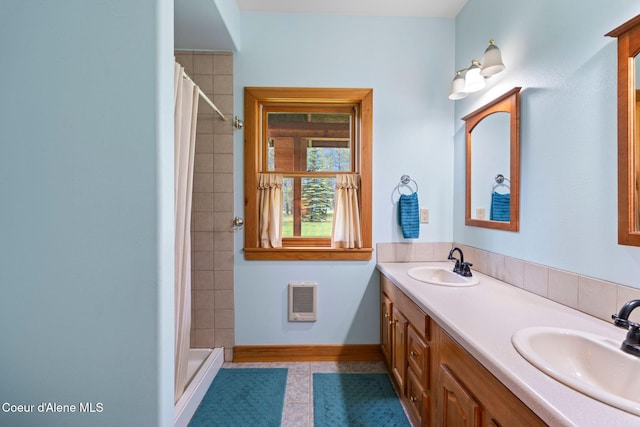 9307 Lakeshore Dr, Sagle, ID 83860 - bathroom with double vanity, tile patterned floors, tiled shower, and heating unit