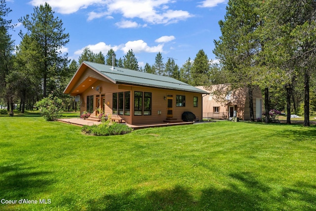 9307 Lakeshore Dr, Sagle, ID 83860 - back of property with a wooden deck, a yard, and a metal roof