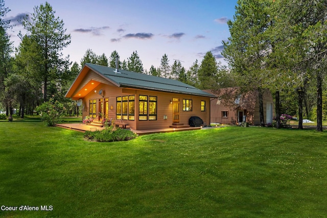 9307 Lakeshore Dr, Sagle, ID 83860 - back of property at dusk featuring a lawn and a deck