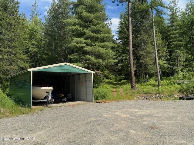 197 Berry Hl, Cocolalla, ID 83813 - garage with a detached carport, driveway, and a view of trees