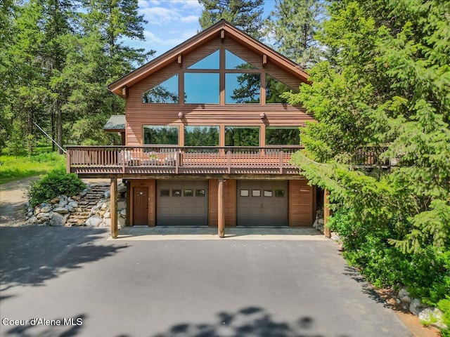 106 Stewart Dr, Blanchard, ID 83804 - view of front facade featuring driveway, a garage, and a wooden deck