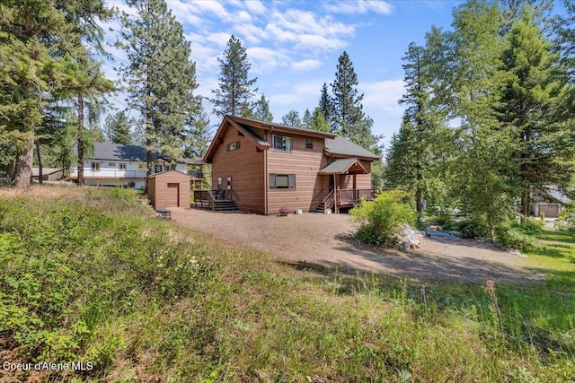 106 Stewart Dr, Blanchard, ID 83804 - back of house featuring dirt driveway and a wooden deck