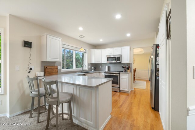 4950 E Frazier Dr, Post Falls, ID 83854 - kitchen with stainless steel appliances, a peninsula, white cabinets, and recessed lighting
