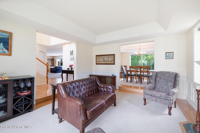 4950 E Frazier Dr, Post Falls, ID 83854 - living area featuring a chandelier, a decorative wall, a raised ceiling, stairs, and wainscoting