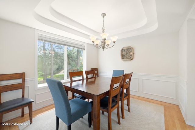4950 E Frazier Dr, Post Falls, ID 83854 - dining space featuring a chandelier, light wood-type flooring, a wainscoted wall, and a tray ceiling