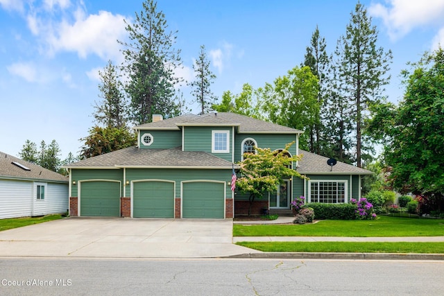 4950 E Frazier Dr, Post Falls, ID 83854 - view of front of house with an attached garage, driveway, a front lawn, a chimney, and brick siding