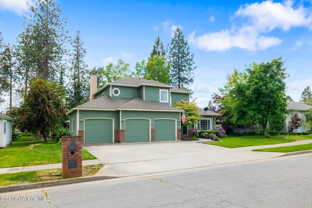 4950 E Frazier Dr, Post Falls, ID 83854 - view of front of house featuring an attached garage, concrete driveway, a front lawn, and a chimney