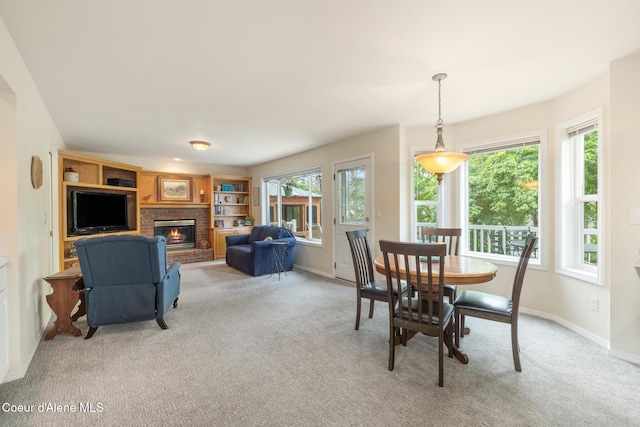 4950 E Frazier Dr, Post Falls, ID 83854 - dining room featuring a fireplace, light carpet, healthy amount of natural light, and baseboards