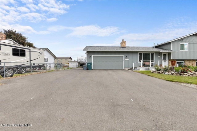 9670 N Meadow Way, Hayden, ID 83835 - tri-level home with a chimney, a garage, asphalt driveway, and a shingled roof