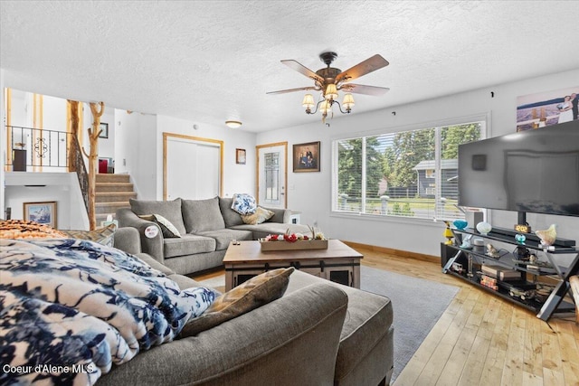 9670 N Meadow Way, Hayden, ID 83835 - living room featuring hardwood / wood-style floors, ceiling fan, a textured ceiling, baseboards, and stairway