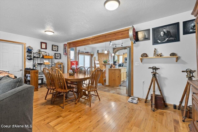 9670 N Meadow Way, Hayden, ID 83835 - dining room featuring a textured ceiling, light wood-style flooring, and baseboards